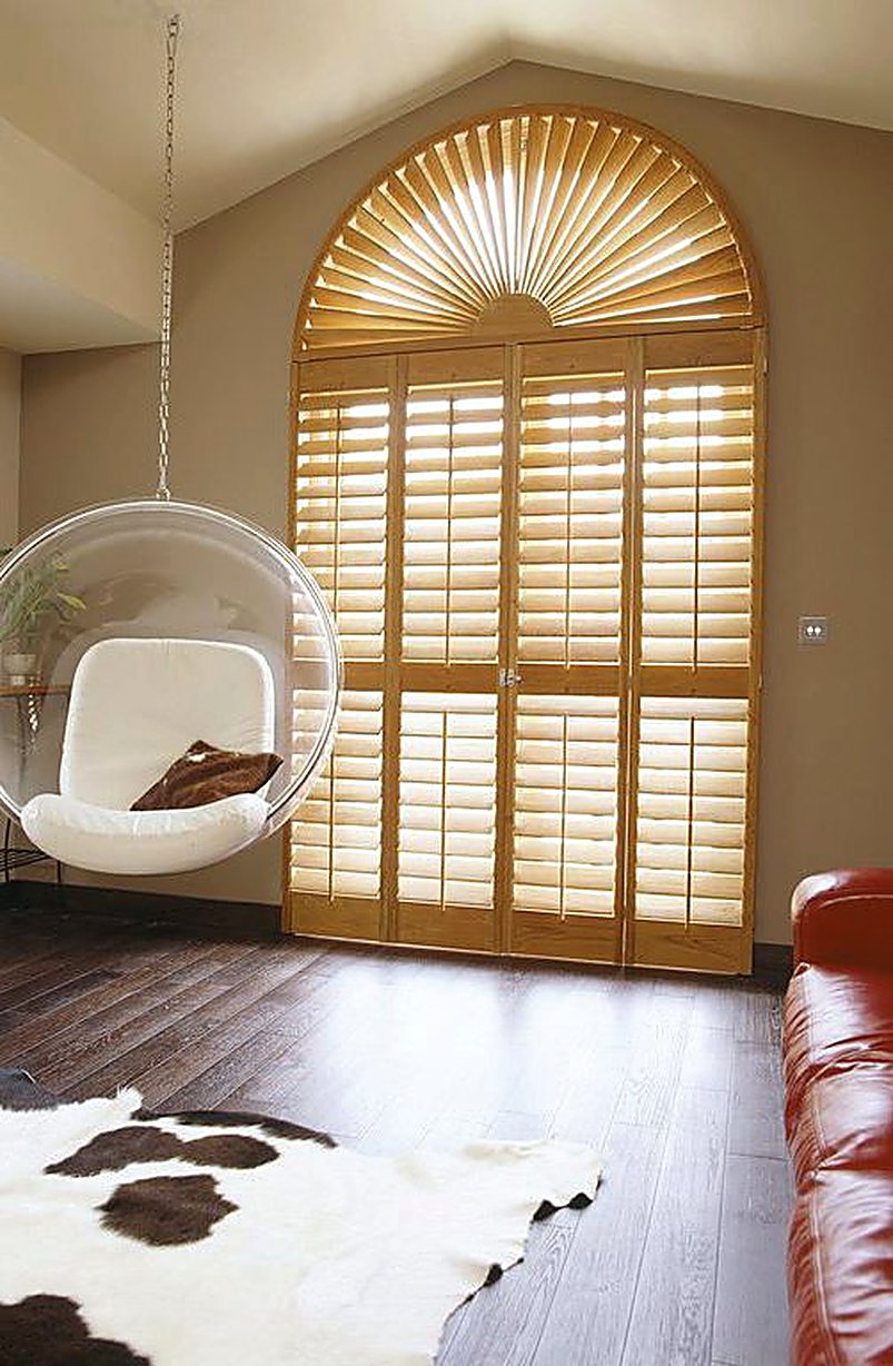 Arched sunburst wooden shutters on tall glazed doors