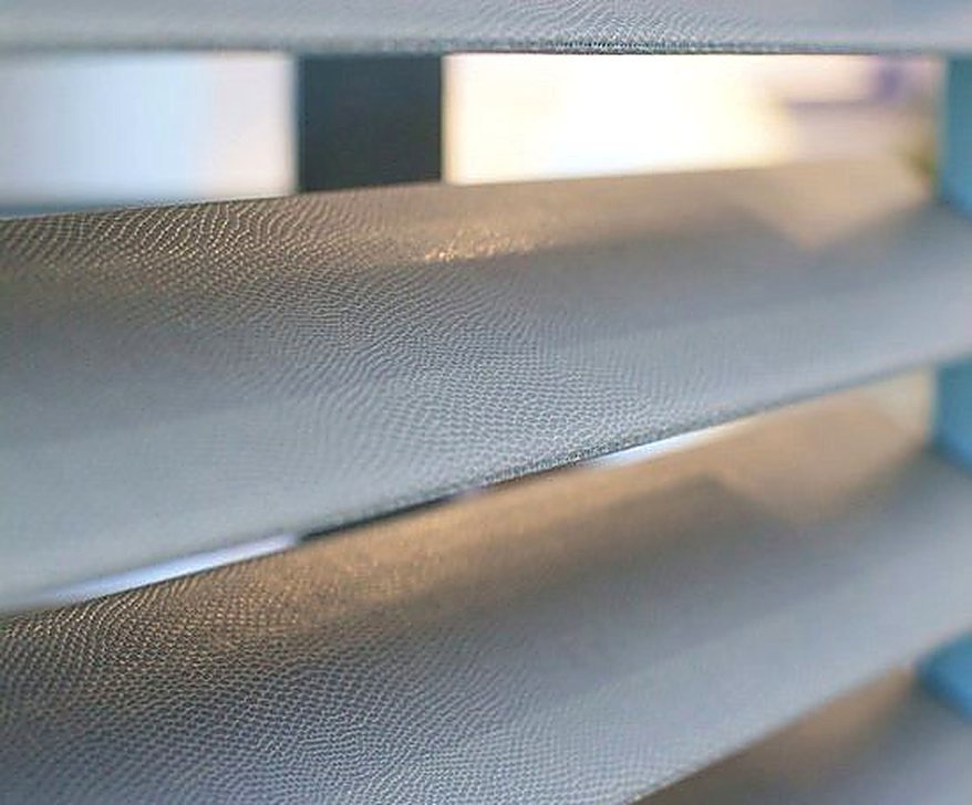 Light glowing through faux leather covered shutter louvres