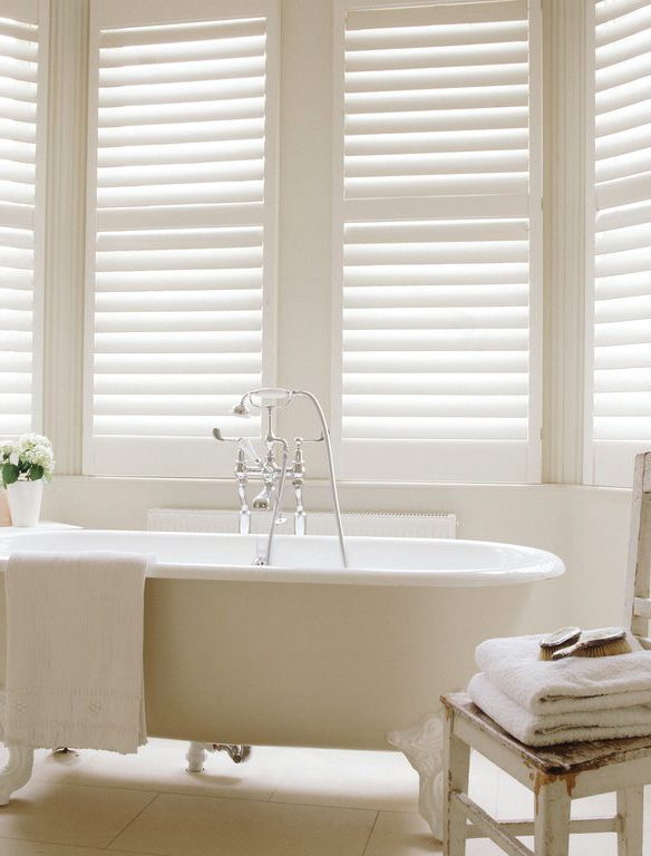 Full height cream shutters in an elegant bathroom