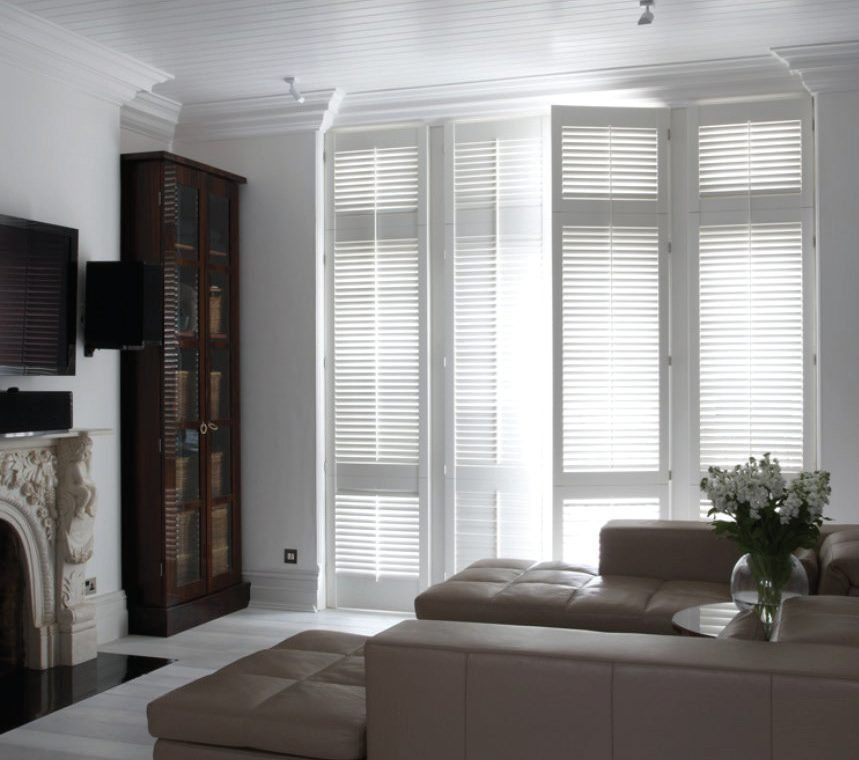 White plantation shutters dressing tall windows in a classic living room